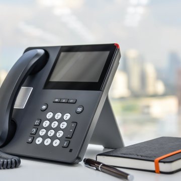 ringcentral business voip service black phone black agenda pen on desk